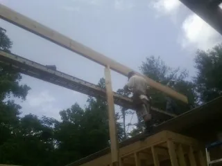 Carpenter setting a ridge beam over a new addition frame — Ice Dam Removal by Roofing Brothers in Fidelity