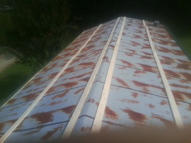 Rusted metal roof panels with new wood purlins before replacement — Storm Damage Roof Repair in Fidelity by Roofing Brothers