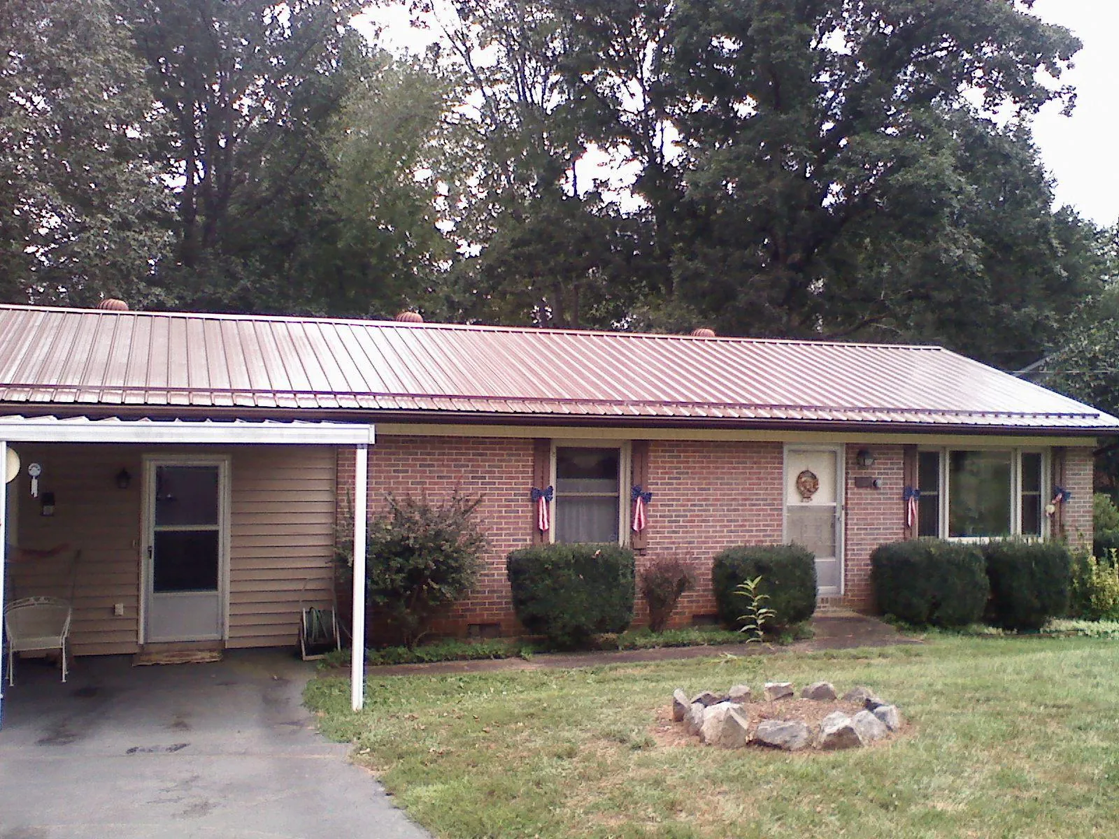 Bronze metal roof and carport on a brick ranch home — Roof Repair work by our crew in Fidelity